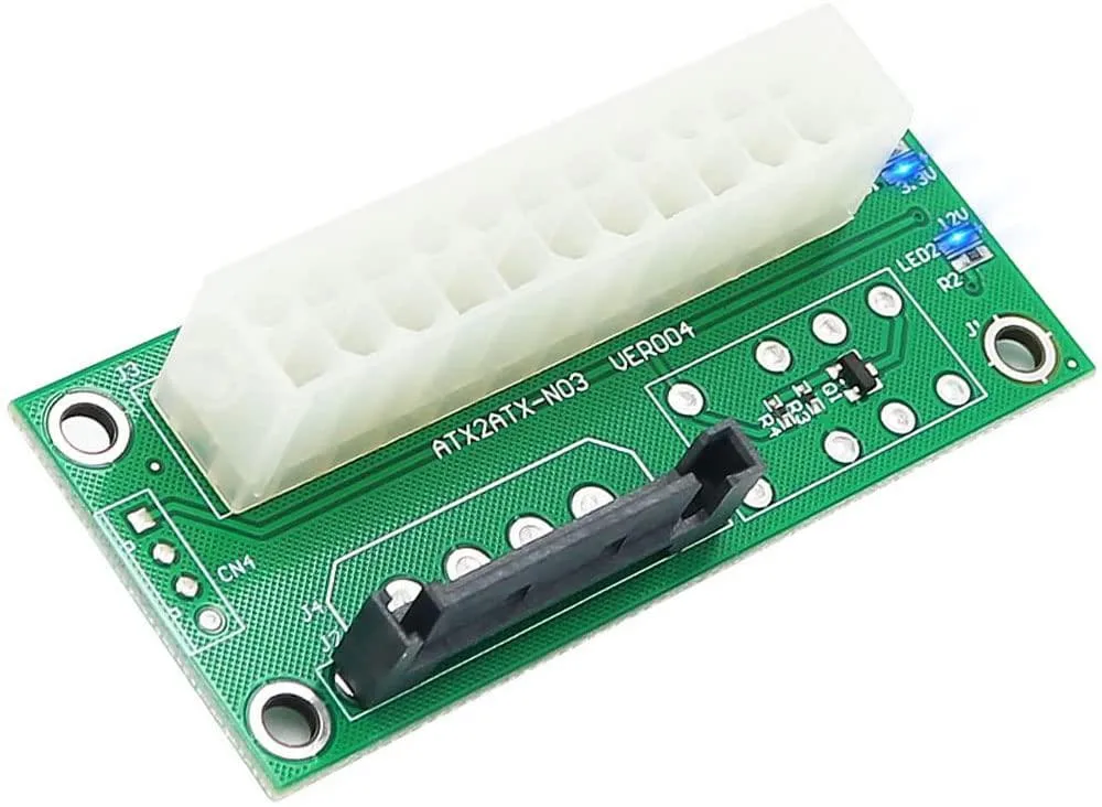 Small green circuit board with SATA 15-pin and 24-pin ATX connectors, 3.3V and 12V status LEDs, and gold contacts