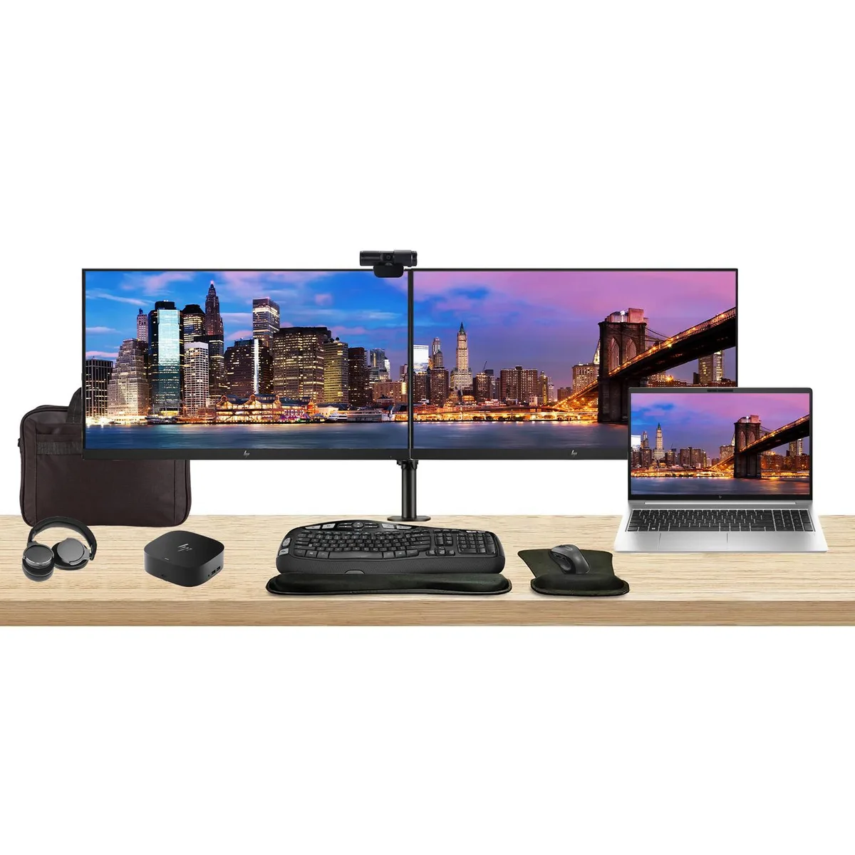 Silver laptop, two black monitors on dual stand, dock, keyboard, mouse, webcam, headphones, bag