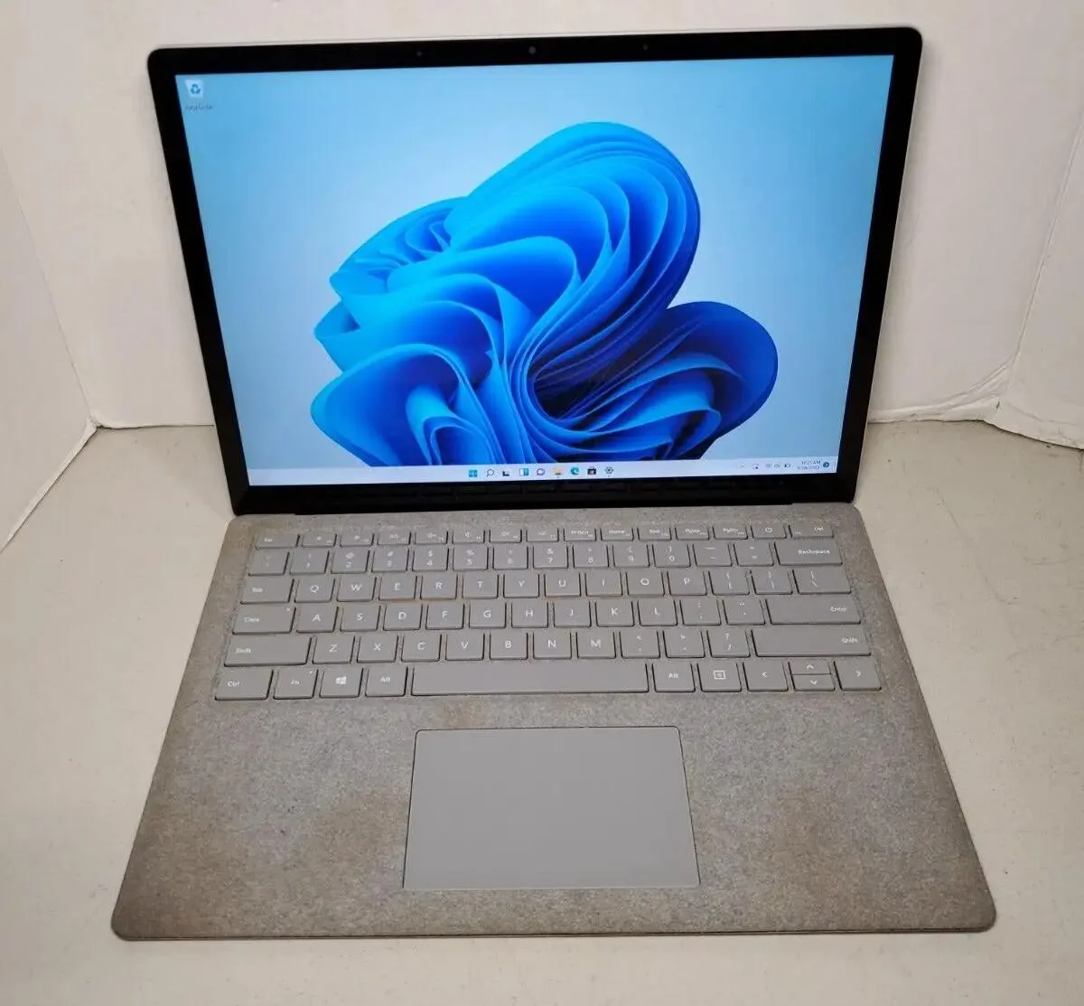 Silver aluminium 13.5 inch laptop closed showing subtle keyboard marks and casing wear