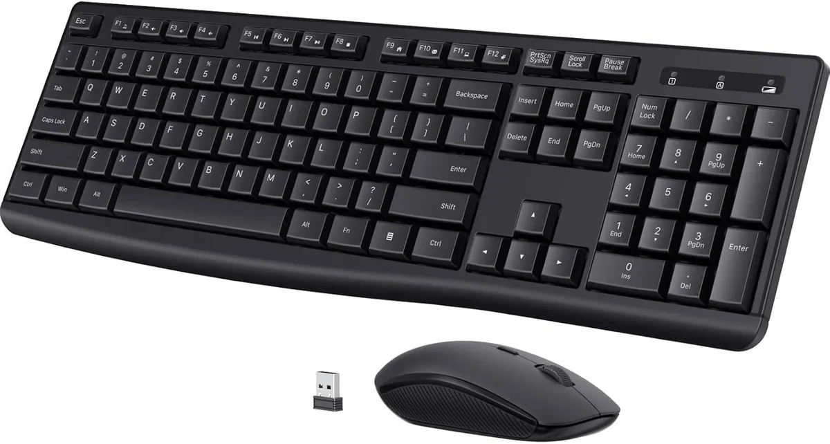 Black full-size wireless keyboard with numeric keypad, low-profile keys and tilt legs, paired with a matching ergonomic mouse