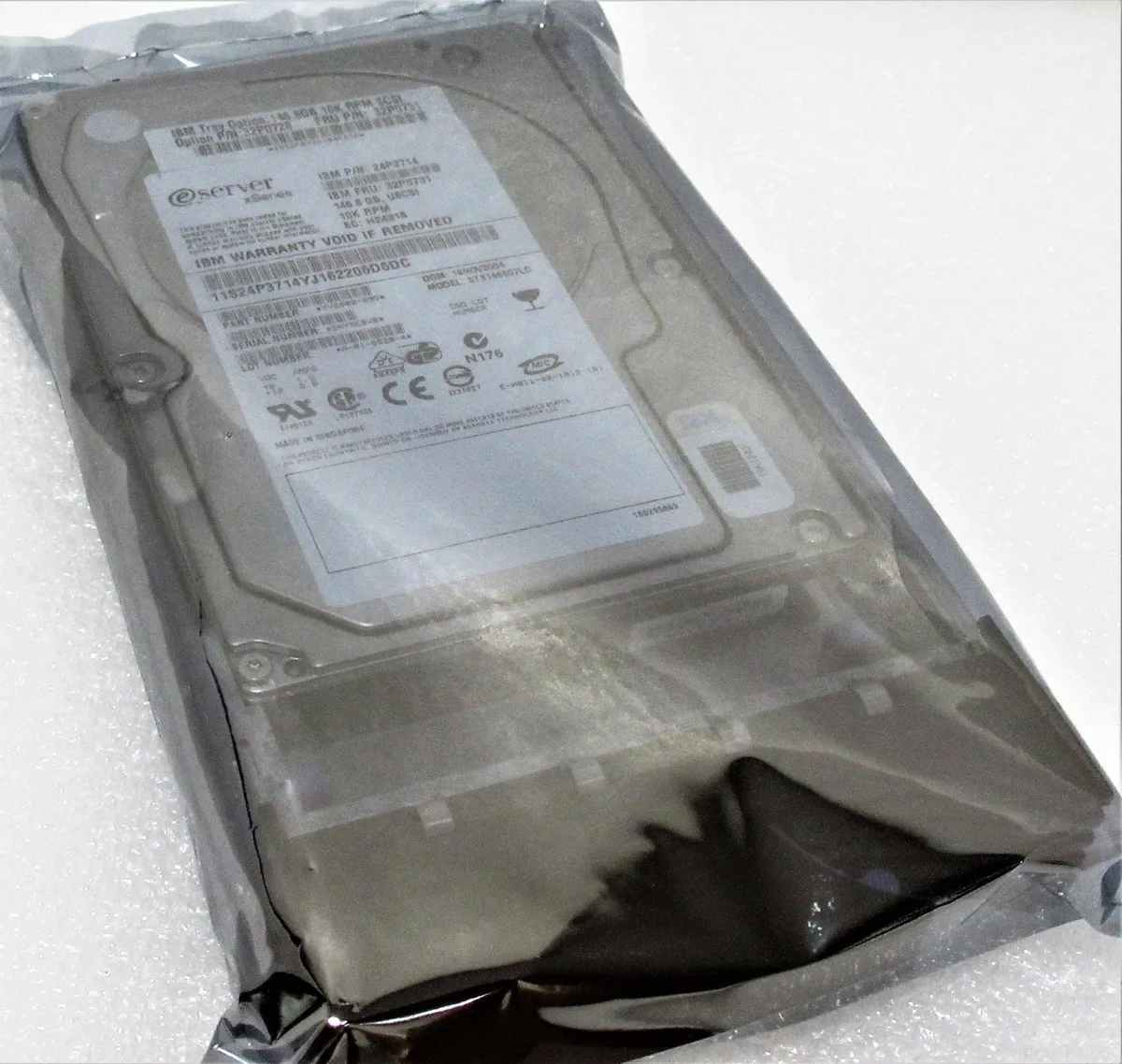 IBM 3.5 inch SCSI hard drive with silver metal casing and 80 pin connector mounted in black plastic hot swap caddy tray